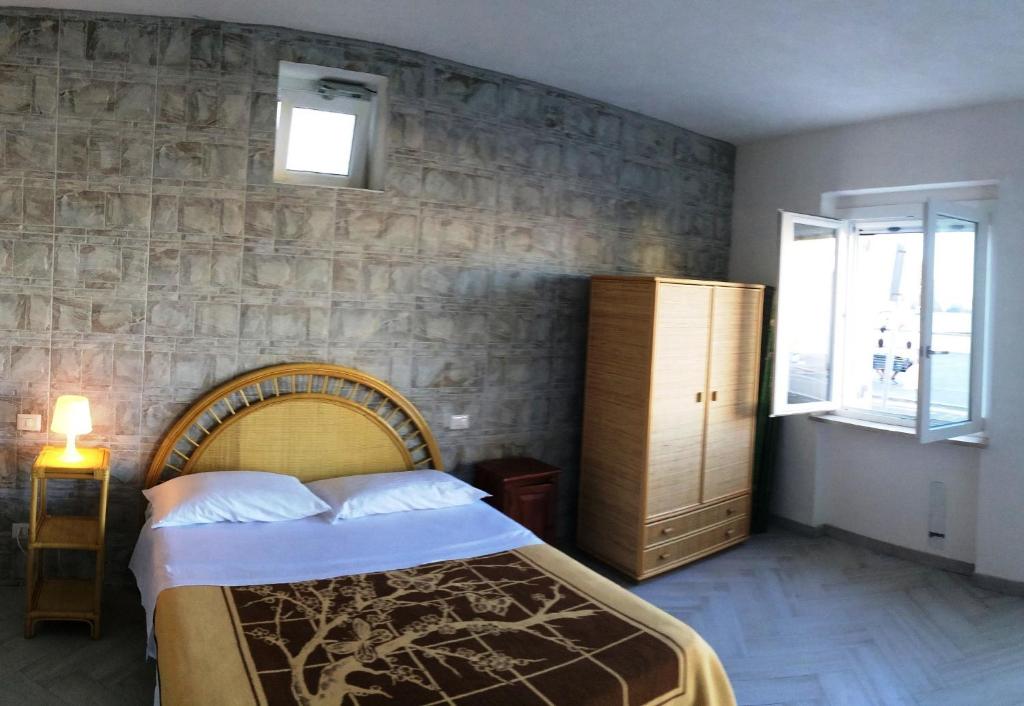 a bedroom with a bed and a stone wall at Il Maestrale - Immobilevante in Ponza
