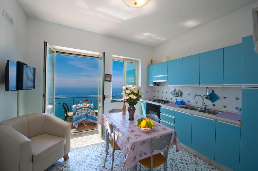 弗洛里的住宿－Sogno Blu，厨房配有蓝色橱柜和鲜花桌