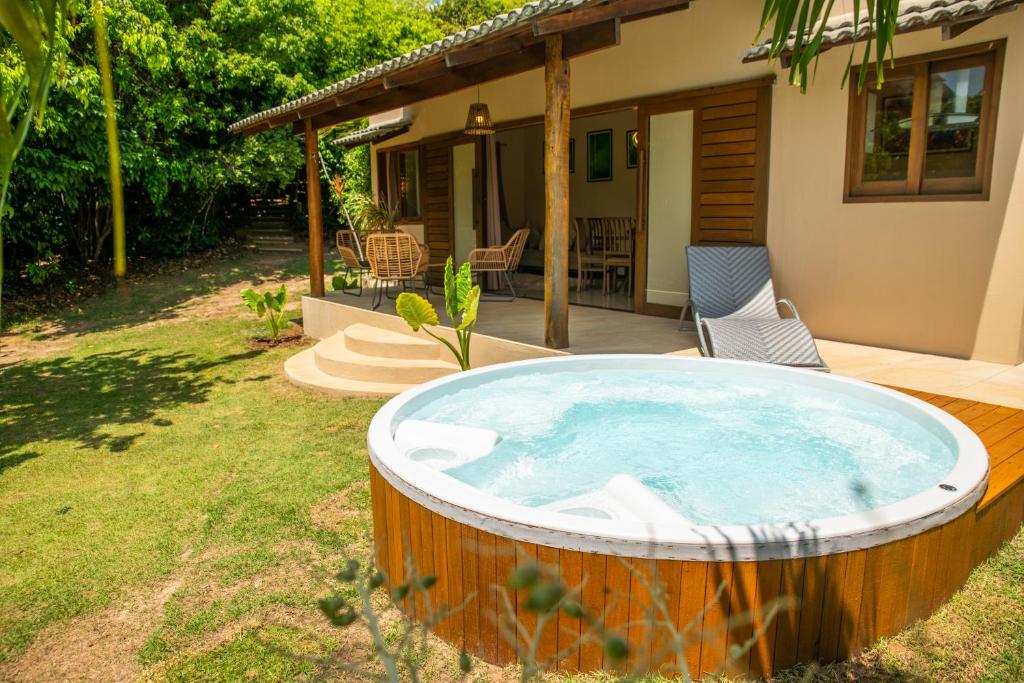 a hot tub in a yard next to a house at Forest House Pipa in Pipa