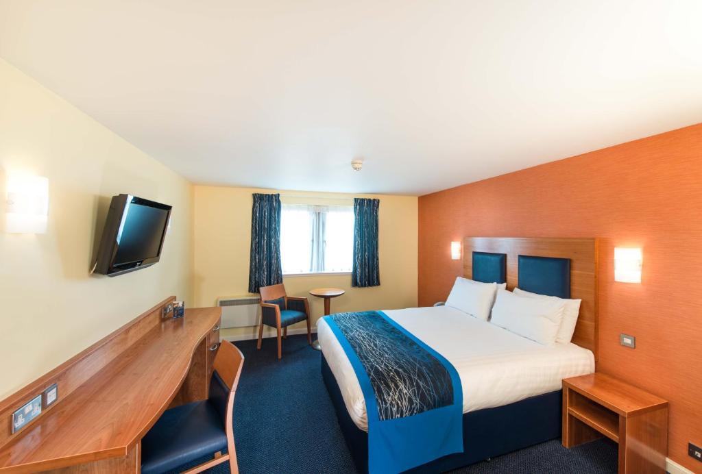 a hotel room with a bed and a television at Leonardo Inn Aberdeen Airport in Dyce