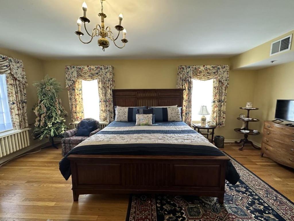ein Schlafzimmer mit einem großen Bett und einem Kronleuchter in der Unterkunft Montague Inn Bed & Breakfast in Saginaw