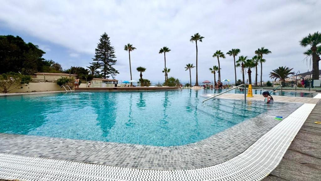 a child is playing in a large swimming pool at Costamar Infinite Sea Views by Deihu Experiences in Los Cristianos