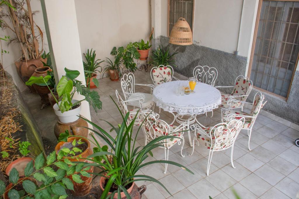 a white table and chairs on a patio with plants at La casa del médico in Dalías