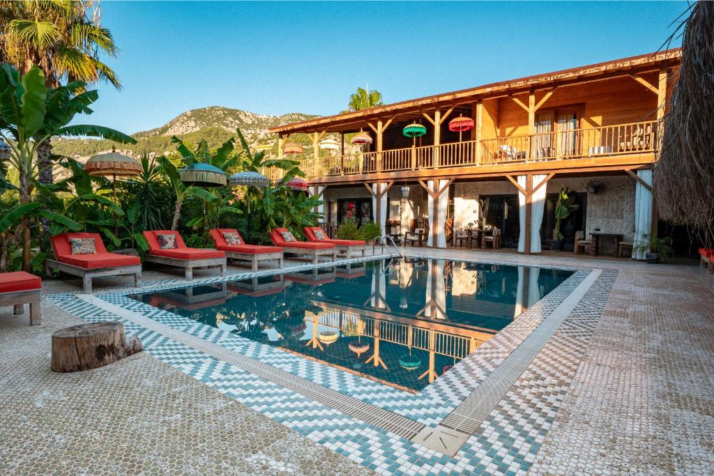 une maison avec une piscine devant une maison dans l'établissement Naturelife Bungalows & SPA, à Çıralı