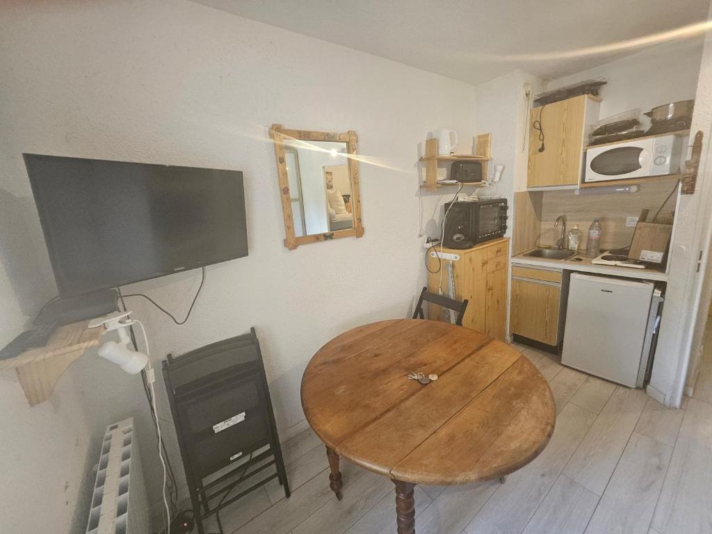 une petite cuisine avec une table en bois dans une pièce dans l'établissement studio a la montagne, à La Foux