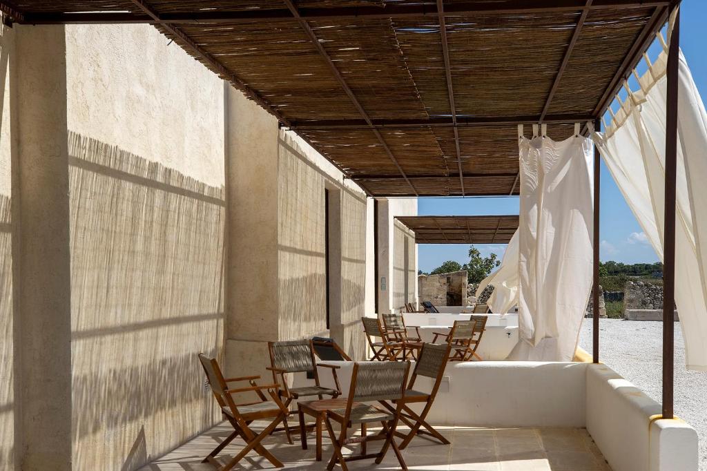 a group of chairs and a table on a patio at Masseria LOGGIA PUCCI in Torre Chianca