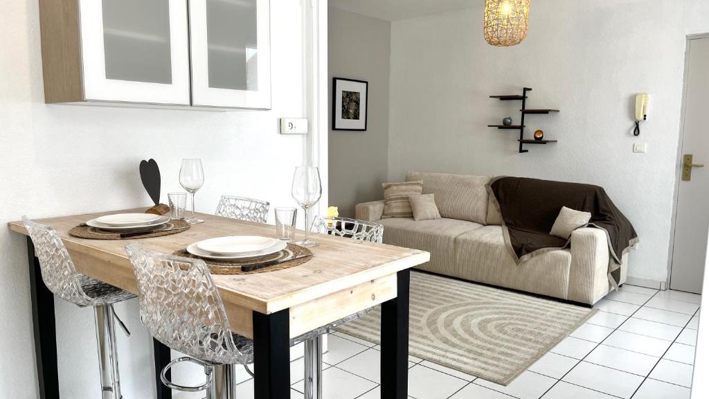 a living room with a table and a couch at Gîte Le 25 in Ingersheim