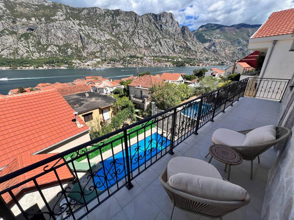 a balcony with chairs and a view of the water at Sunny Days Villa in Prčanj