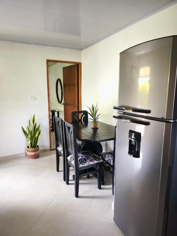 Una cocina con refrigerador y una mesa con sillas. en Aparta estudio en San Rafael, en San Rafael