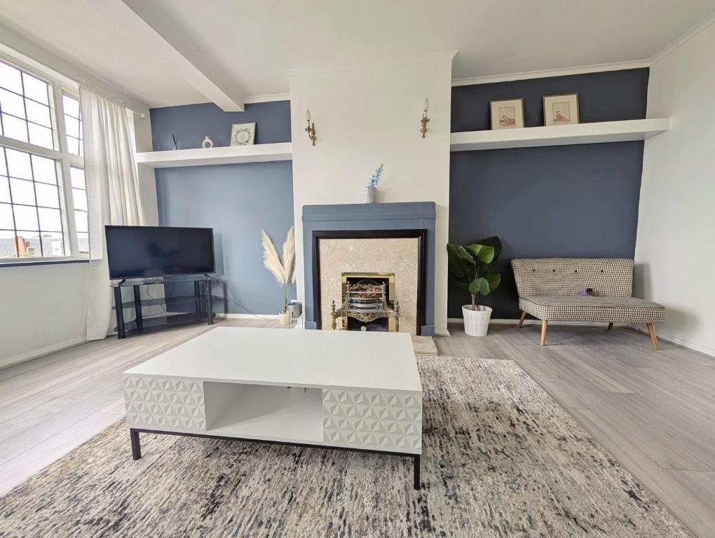 a living room with a white coffee table and a fireplace at Luxury 1 bed apartment in East Croydon in South Norwood