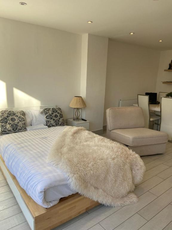 a bedroom with a white bed with a rug on it at Blue House in Stone Grove