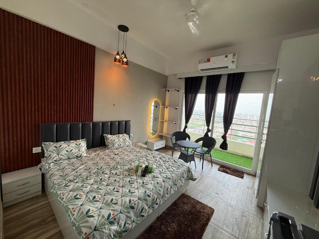 Un dormitorio con una cama y una ventana grande. en Lumora lofts, en Greater Noida