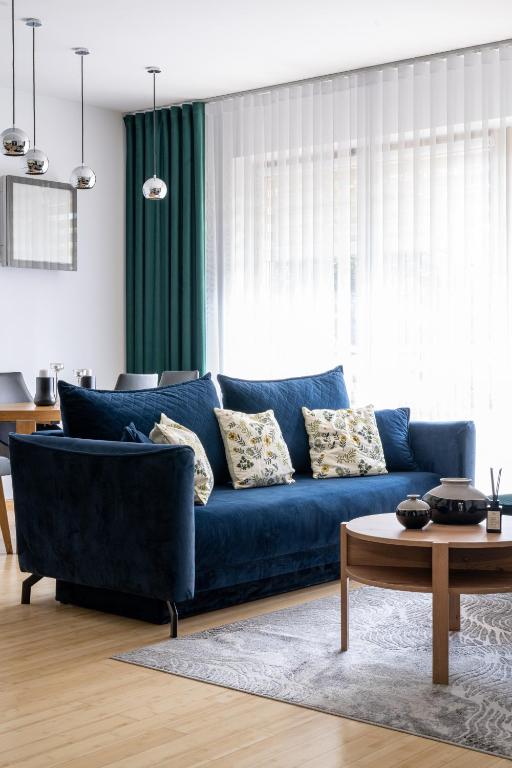 a blue couch in a living room with a table at Aqua Park Residence VIPAPARTAMENTY in Zakopane