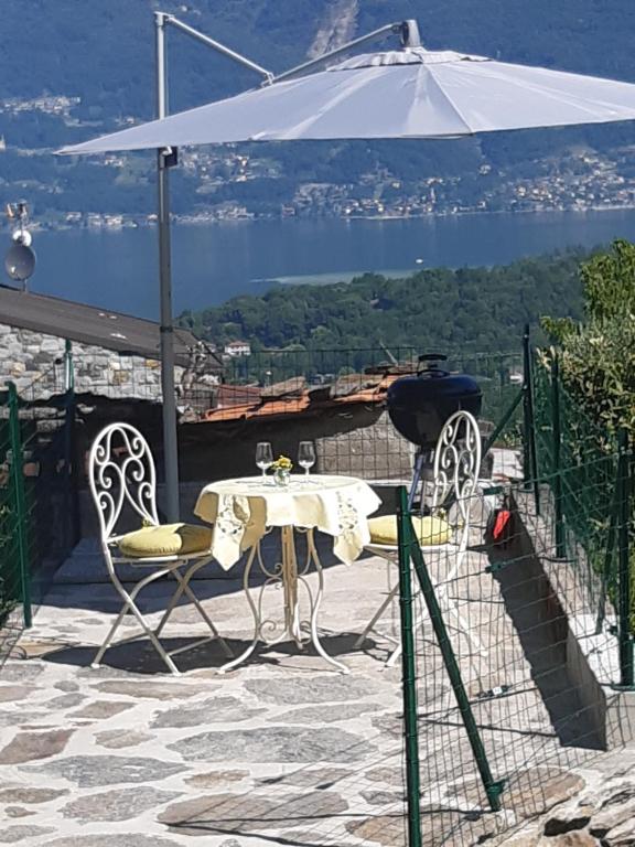 a table and chairs on a patio with an umbrella at L'incantevole vista in Colico