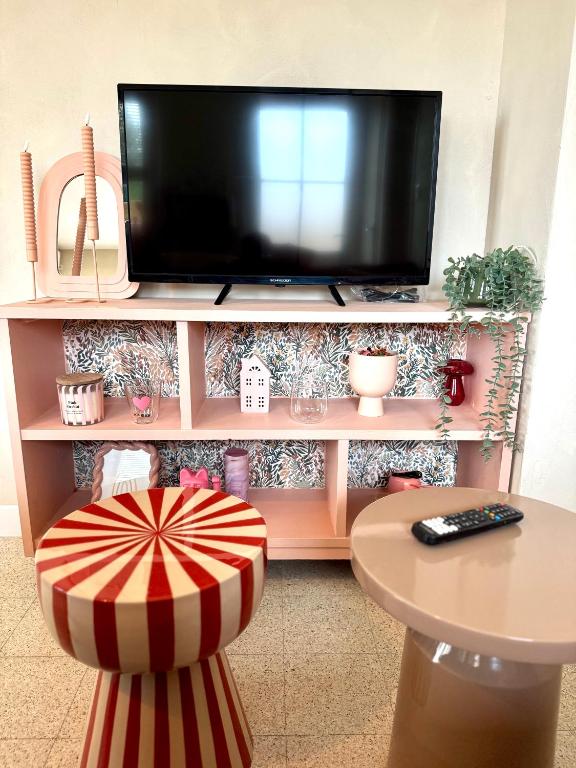 a tv sitting on top of a tv stand at Le kiosque in Acy-Romance