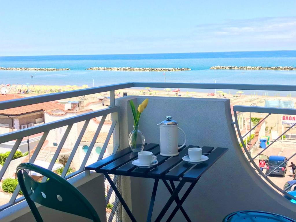 ein Tisch auf einem Balkon mit Blick auf das Meer in der Unterkunft Casa Stefania Igea Marina Vista Mare in Bellaria-Igea Marina