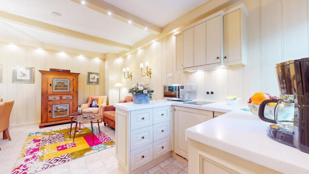 a kitchen with white cabinets and a living room at Oener Reet in Kampen