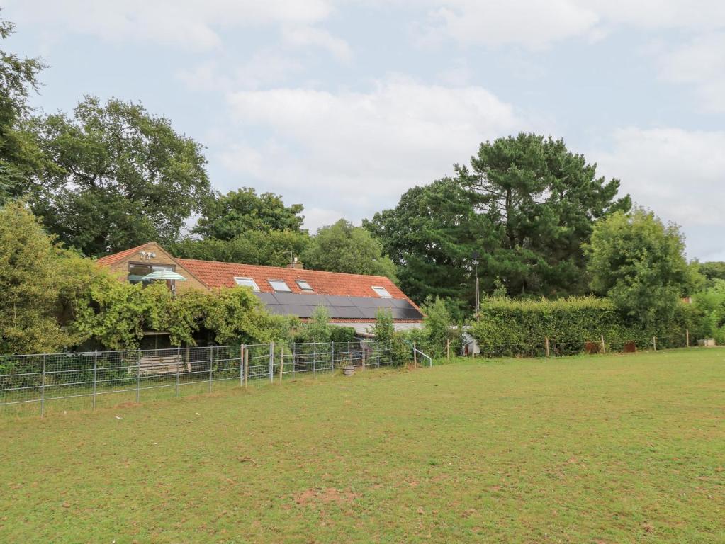 a field with a fence and a house in the background at Uplands in Compton