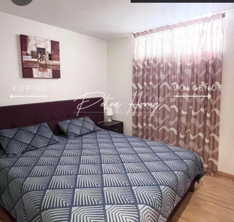 a bedroom with a bed with a blue and white comforter at Quickcasaspain sl in Rojales