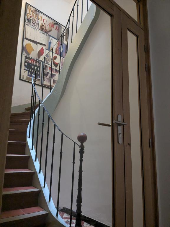 a stairway with a stair railing and a door at Le petit Ceretan in Céret