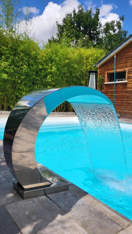 a swimming pool with a fountain in the middle at Le Mas ROLLAND -Chambres de charme -SPA sauna & jacuzzi - Label Qualité Tourisme Occitanie - Millau - Gorges du Tarn in Compeyre