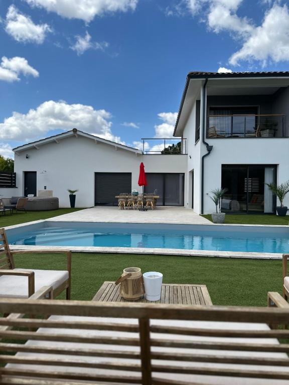 a villa with a swimming pool and a house at Villa familiale & plongeons in Sainte-Eulalie