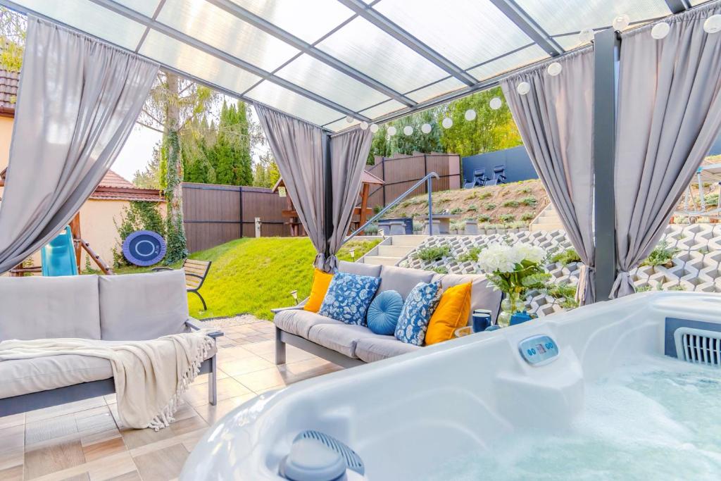 a hot tub in a yard with a patio at Panorámaház Bükkszék in Bükkszék