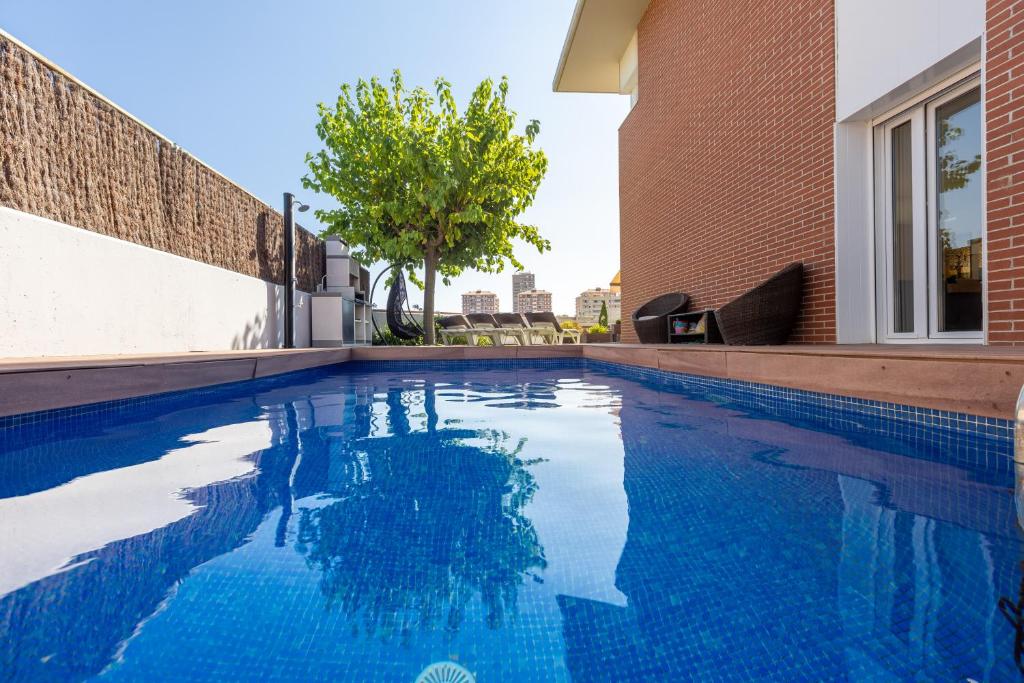 a swimming pool with blue water in a building at Villa Beach Barcelona in Montgat