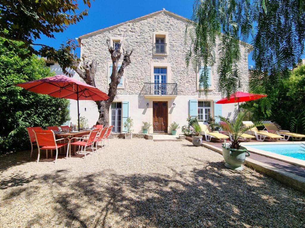 a house with a table and chairs and a swimming pool at La maison des Vendangeurs 6 in Olonzac