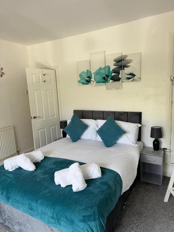 a bedroom with a large bed with towels on it at Elegant 3-Bedroom Home For groups & Families, Patio, Fast Wi-Fi & Parking in Loughborough