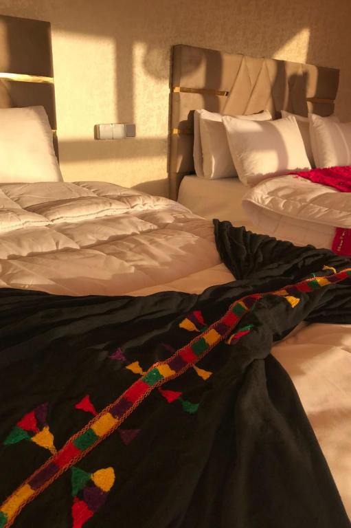a bed with a black blanket on top of it at Agafay Luxury desert Camp - Glamping Experience in Aït Mazou