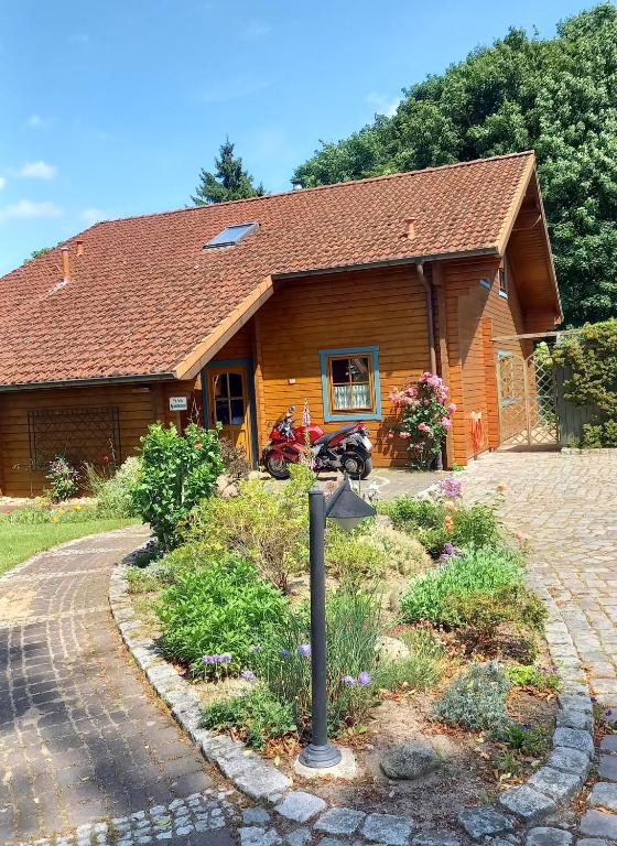 a log house with a driveway in front of it at FeWo Wardersee in Rohlsdorf