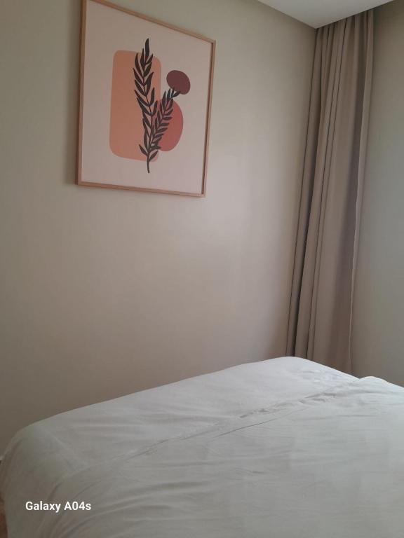 a bedroom with a bed with a picture on the wall at Central in Agadir