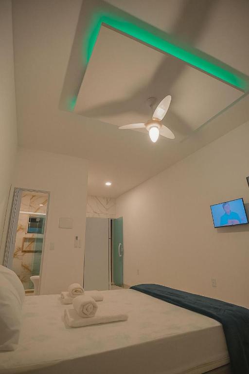 a bedroom with a bed with a ceiling fan at Pousada encanto do sol in Búzios