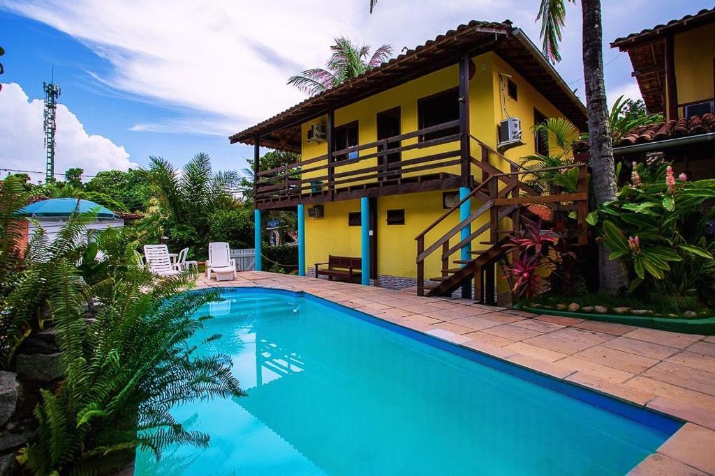 una casa con piscina delante de una casa en Pousada Arraial Lua Crescente, en Arraial d'Ajuda