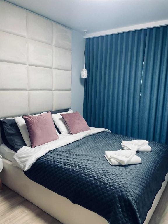 a bedroom with a large bed with blue curtains at Apartament NATALKA SPA ul Traugutta in Wrocław