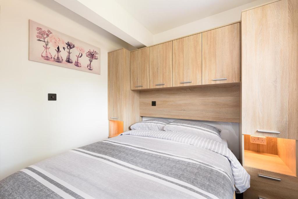 ein Schlafzimmer mit einem Bett und Holzschränken in der Unterkunft 93 High Street in Redbourn