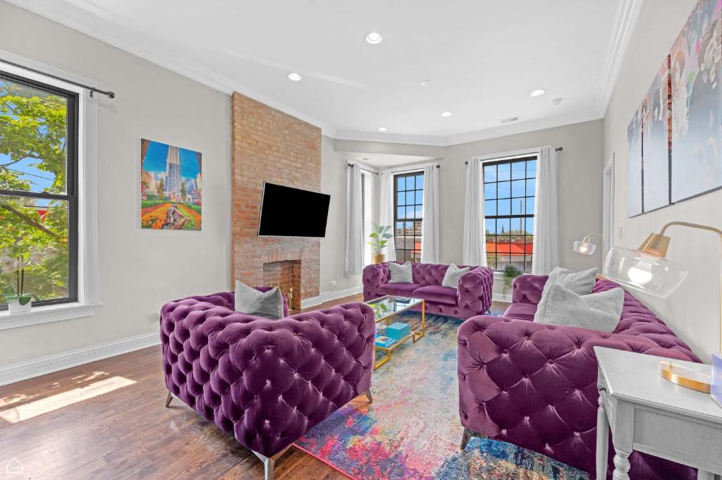 a living room with purple chairs and a tv at Modern, Spacious 3br Apt Minutes To Downtown! in Chicago
