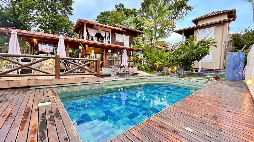a house with a swimming pool and a wooden deck at Pousada Blue Ocean in Itacaré