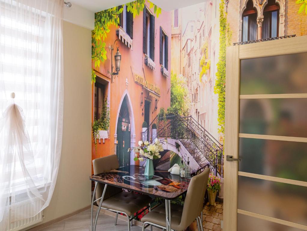 Un comedor con una mesa con un cuadro en la pared. en Sky House VENETIA Exclusive Apartments, en Chişinău