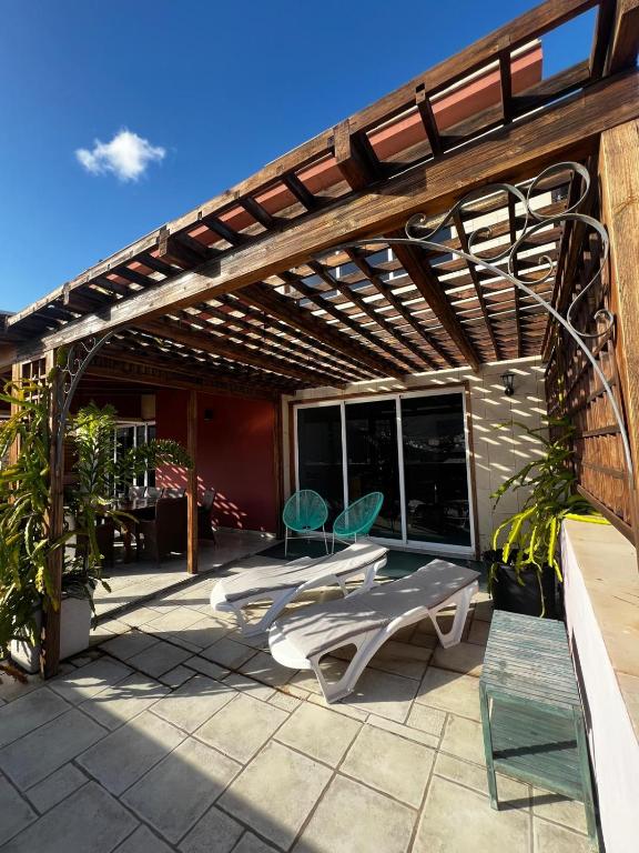 a pergola with two chairs and a table on a patio at Gomera Isla Mágica in San Sebastián de la Gomera