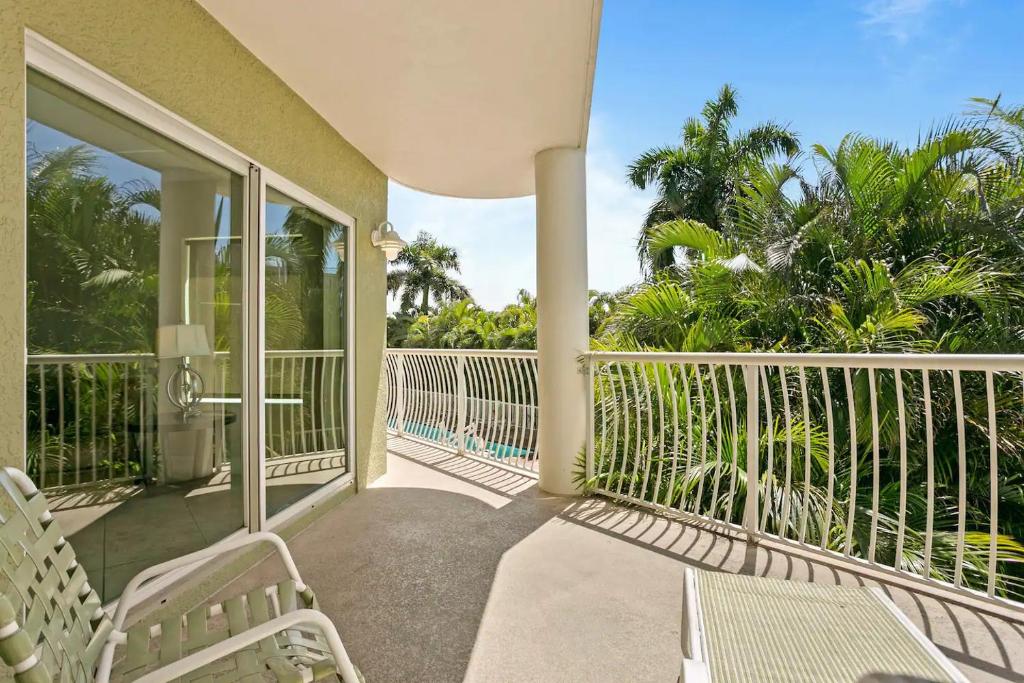een balkon van een huis met stoelen en bomen bij Modern, Spacious & Clean Beach Getaway in St Pete Beach