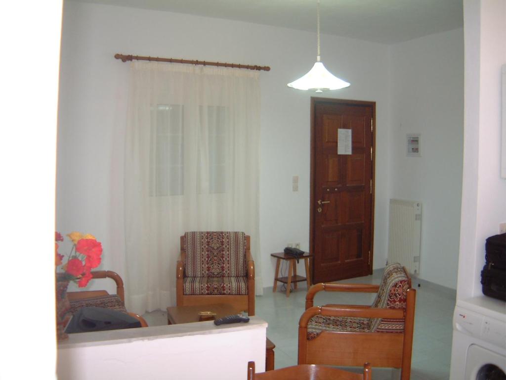 a living room with two chairs and a window at Steve Apartments in Áno Garoúna