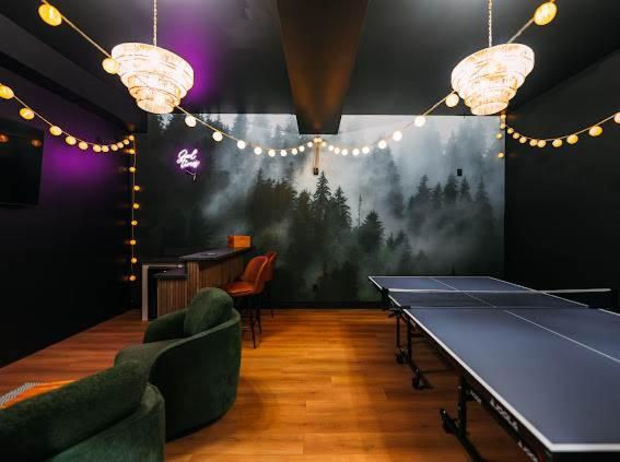 a ping pong room with a ping pong table and chairs at The Greenhouse with Indoor Slide close to Hocking Hills in South Bloomingville