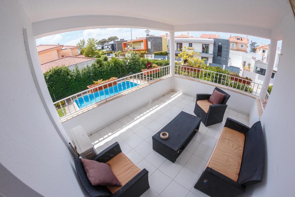 a view of a balcony with chairs and a pool at Casa do Marmeleiro Guest House in Alcabideche