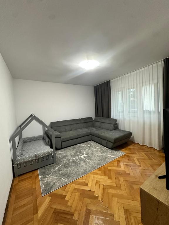 a living room with a couch and a wooden floor at Apartament Poiana Câmpina in Poiana Campina