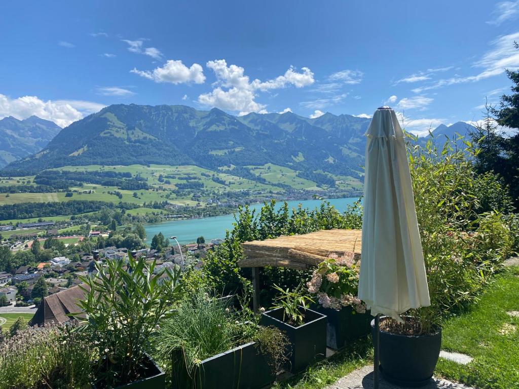 an umbrella sitting on a hill with a view of a river at Chalet Seeblick in Sarnen