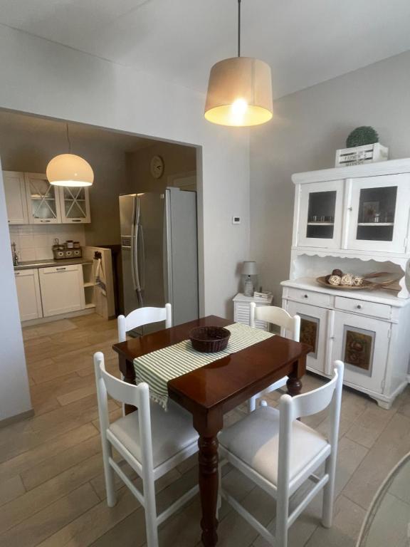 a kitchen with a wooden table and white chairs at Appartamento in Villa in Mondaino