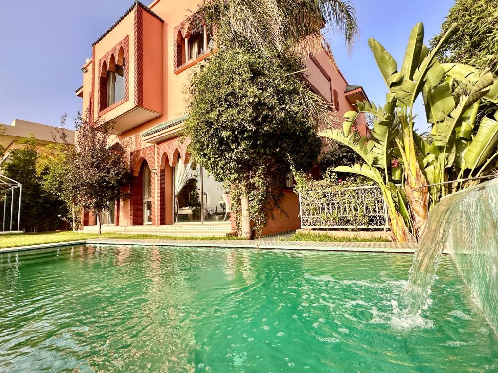 een zwembad met een fontein voor een gebouw bij Chanel in Marrakesh