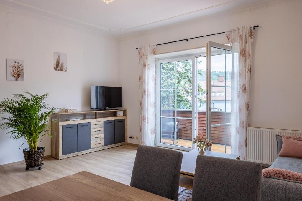 a living room with a tv and a large window at Steinmetz-Haus in Mariazell